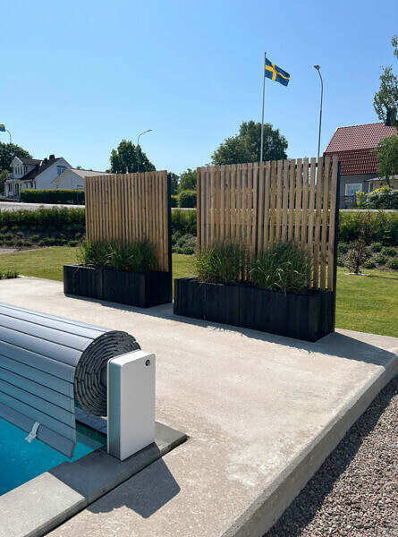 Foto på en nyanlagd trädgård som designats av Östgöta trädgårdsdesign. Insynsskydd vid pool. Bild 1.